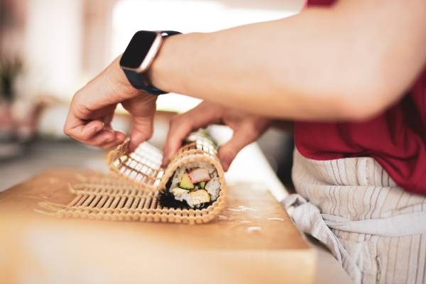 A person is making a sushi roll.