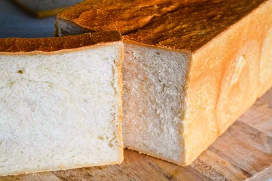 A loaf of shokupan on a wooden chopping board